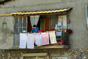 Hausfrau auf dem Balkon beim Wäsche aufhängen